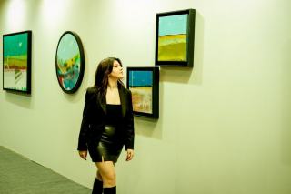 Visiteuse arrêtée devant un grand tableau abstrait dans une galerie